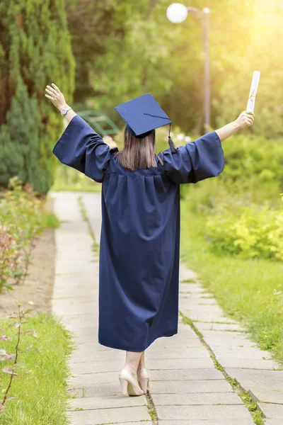 Young woman graduate put her hands up and celebrating — Stock Photo, Image