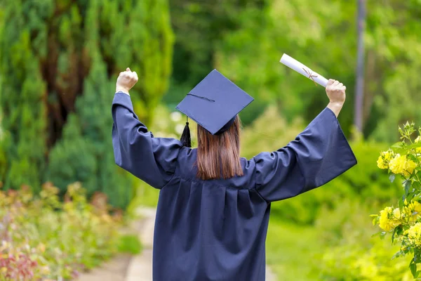 Young woman graduate put her hands up and celebrating — Stock Photo, Image
