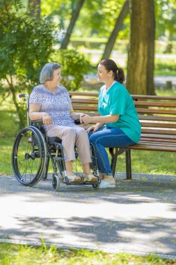 Caregiver konuştuğu tekerlekli sandalye açık kadın kıdemli devre dışı