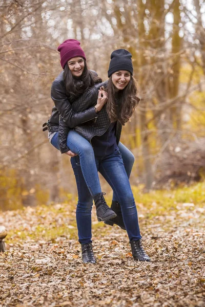 Dos chicas divirtiéndose en el parque de otoño —  Fotos de Stock