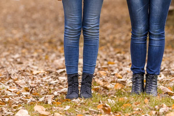 Dos niñas piernas en botas en hojas de otoño —  Fotos de Stock