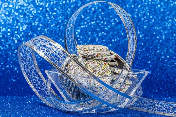 Цветные шоколадные кольца в миске с рождественским декором на блюзе — стоковое фото