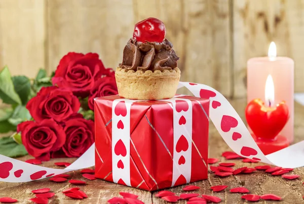 Cupcake with cherry over red gift box — Stock Photo, Image