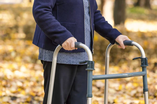 Mujer mayor caminando con andador en el parque de otoño — Foto de Stock