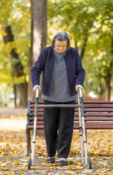 Kvinna med rullator promenader utomhus — Stockfoto