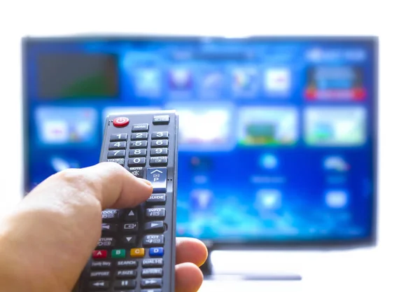 Smart tv and hand pressing remote control — Stock Photo, Image