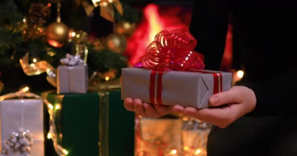 Mujer Colocando Regalos Bajo Árbol Navidad Cerca Chimenea Mostrando Regalo — Vídeo de stock