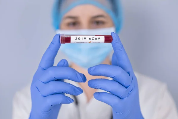 陽性のコロナウイルス検査血液サムと看護師保持試験管 — ストック写真