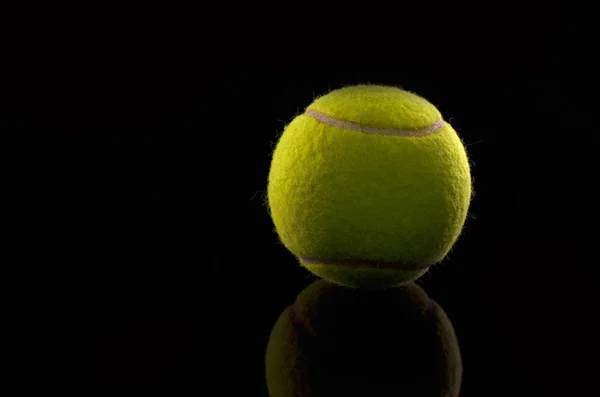 Tennisball auf schwarzem Hintergrund — Stockfoto