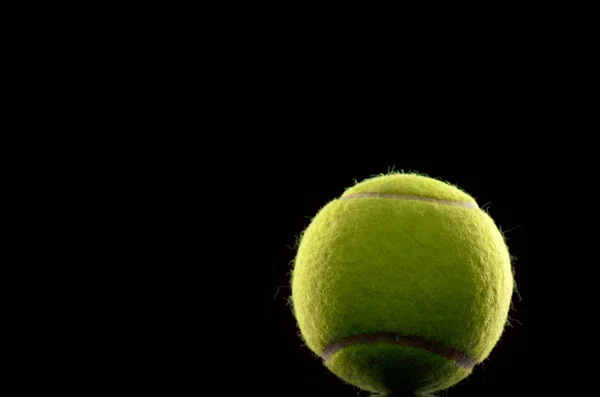 Теннисный мяч на черном фоне — стоковое фото