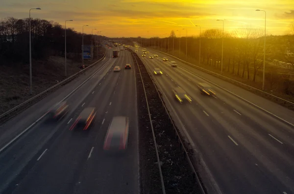 Highway traffic vid solnedgången — Stockfoto