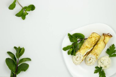 Nane ile beyaz bir plaka üzerinde peynir soslu krep bırakır