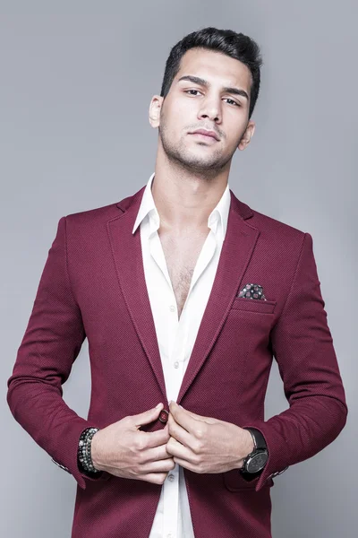 Young and attractive middle eastern man portrait in suits on gray background, studio shot