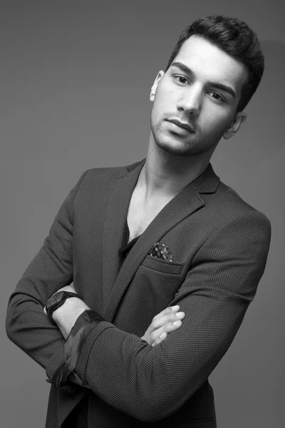 Young and attractive middle eastern man portrait in suits on gray background, studio shot