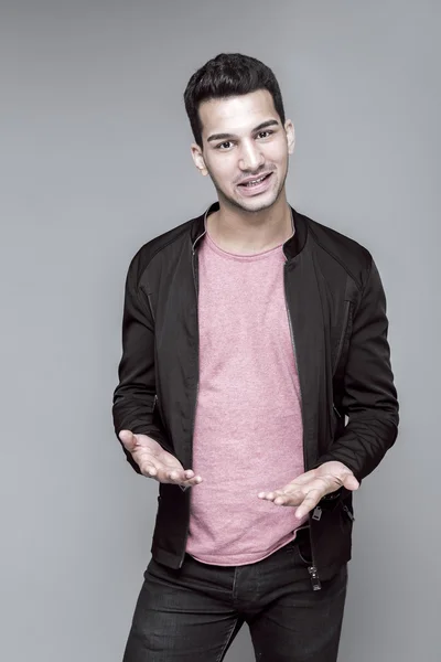 灰色の背景は スタジオ ポートレートにピンクのセーターで若いハンサムな男 — ストック写真