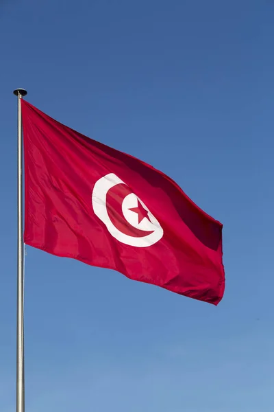 Τυνησιακό σημαία κυματίζει στο μπλε του ουρανού — Φωτογραφία Αρχείου
