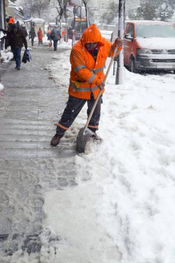 Municipality employees working to clean the sidewalks from snow for pedestrians in Sisli, Istanbul. clipart