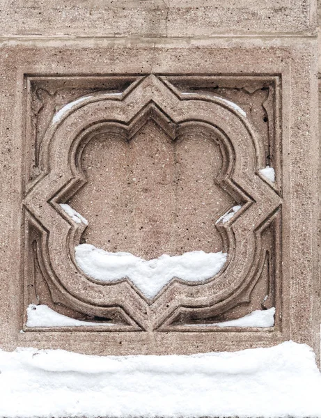 Ornamental detail on a stone wall partly covered with snow, architectural detail, winter concept — Stock Photo, Image