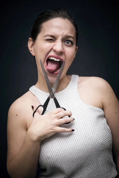 Young and beautiful girl holding a pair of scissors — Stock Photo, Image