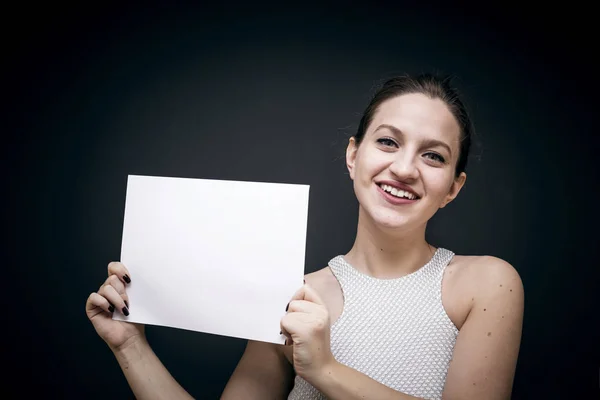 Молодая и красивая девушка показывает бумагу — стоковое фото