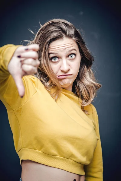 Ung och attraktiv blond kvinna med ett ogillande, ogillande gest och ansikts uttryck — Stockfoto