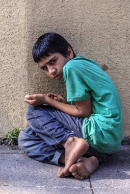 Istanbul, Turkey - July 5, 2016: Little Syrian boy begging in the street in Istanbul. Millions of Syrians had to leave their homeland during the war in Syria. clipart