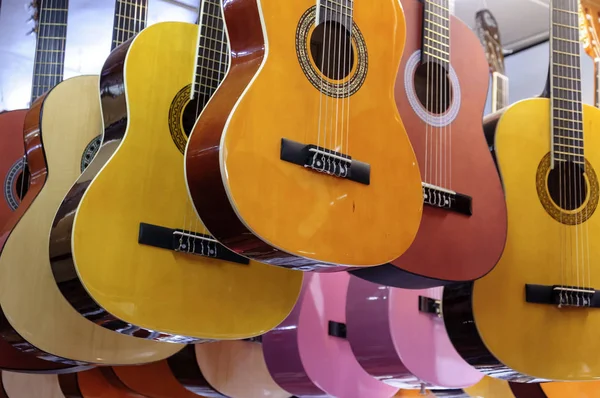 Muchas guitarras clásicas colgando en el techo de una tienda — Foto de Stock