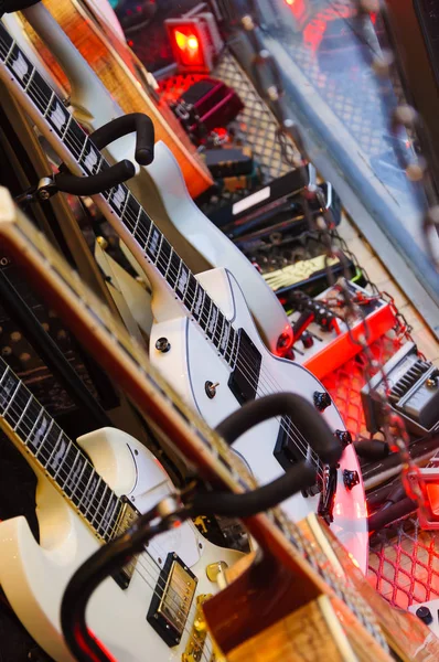 Many electric guitars hanging on the wall of a store