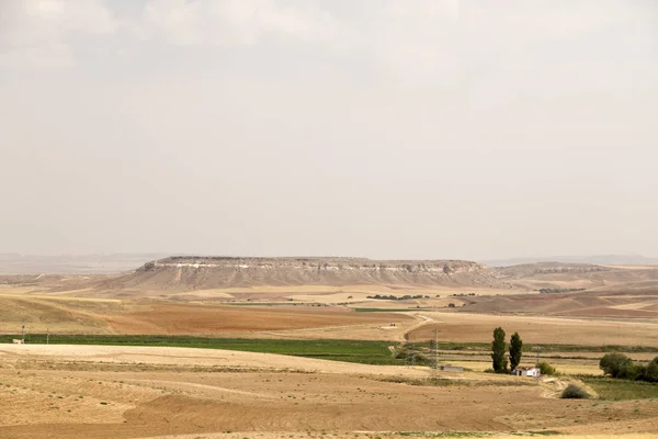 View of flat lands and small hills of the Central Anatolian geography from the road. Central Anatolia has arid climate with hot summers and extremely cold winters.