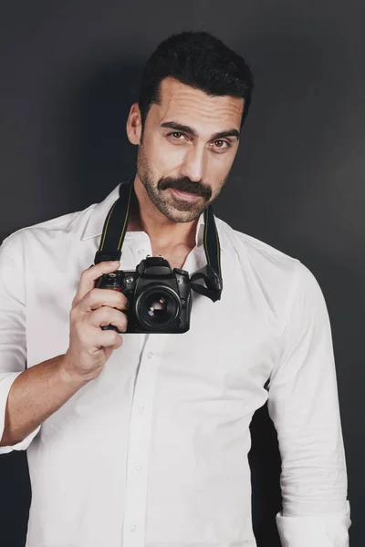 Young handsome photographer with beard and mustache studio portr