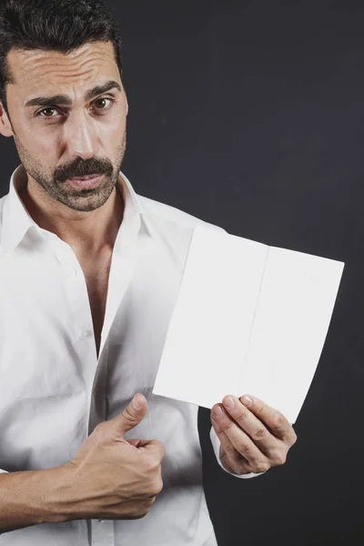 Młody człowiek w białej koszuli czytania broszury — Zdjęcie stockowe