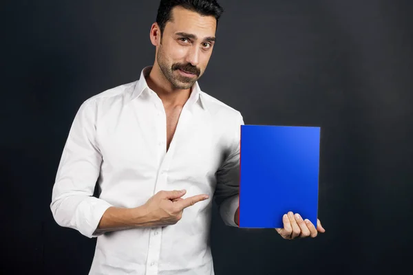 Young man in white shirt reading a booklet — Stock Photo, Image