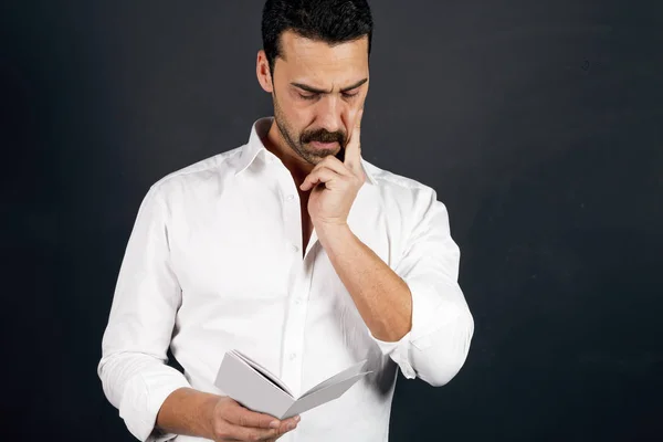 Joven con camisa blanca leyendo un folleto — Foto de Stock