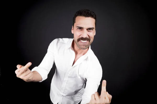 Young handsome man showing fuck off hand gesture — Stock Photo, Image