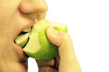 kadın üzerinde beyaz izole bir yeşil elma ısırdı