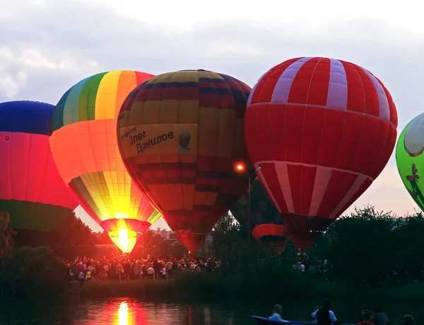 在黄昏的天空中飞行的热空气气球湖附近 — 图库照片
