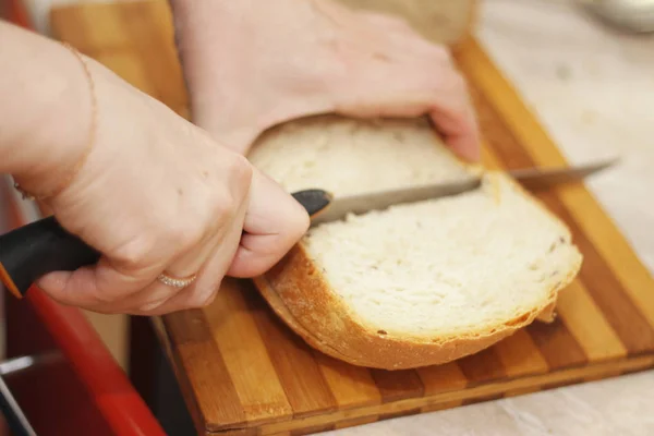 Kobieta, cięcia chleba na biurko z drewna — Zdjęcie stockowe