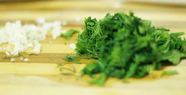 Cutting parsley and garlic on the wood desk — Stock Photo, Image