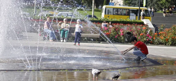 在城镇中心的溅喷泉附近的孩子 — 图库照片