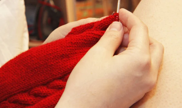 Vrouw breit met breinaalden rode trui van natuurlijke woole — Stockfoto