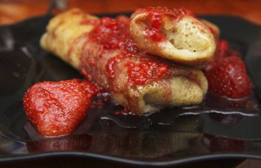 Süzme peynir ve çilek reçeli o tarafından doldurulmuş krep kadar haddelenmiş