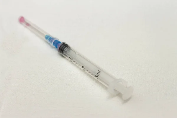 One syringe with cap and needle after using on the white bckgrou — Stock Photo, Image