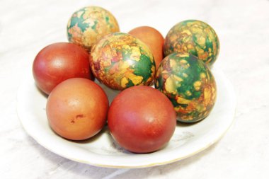 Beyaz tabakta yığın tarafından yerleştirilen renkli Paskalya yortusu yumurta