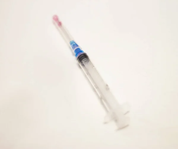 One syringe with cap and needle after using on the white bckgrou — Stock Photo, Image