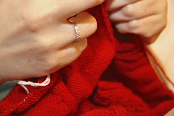 Nő kötögetni, kötőtű piros pulóvert a természetes woole — Stock Fotó