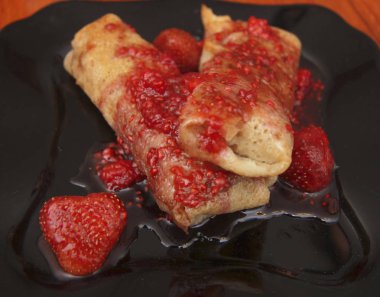 Süzme peynir ve çilek reçeli o tarafından doldurulmuş krep kadar haddelenmiş