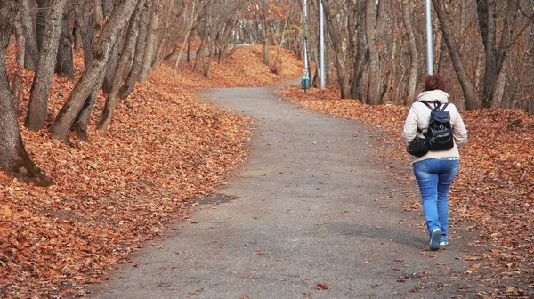 Junge Frau läuft im Herbstpark aus nächster Nähe — Stockfoto