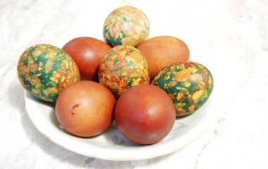 Beyaz tabakta yığın tarafından yerleştirilen renkli Paskalya yortusu yumurta