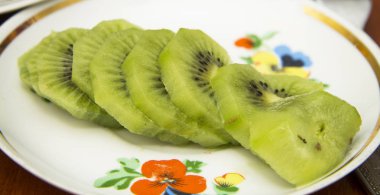 Taze dilimlenmiş kivi beyaz plaka üzerinde