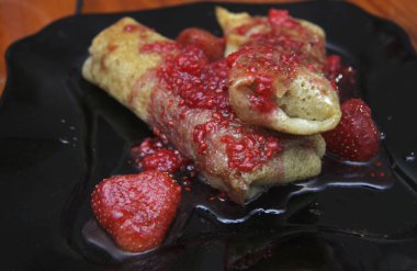 Süzme peynir ve çilek reçeli o tarafından doldurulmuş krep kadar haddelenmiş